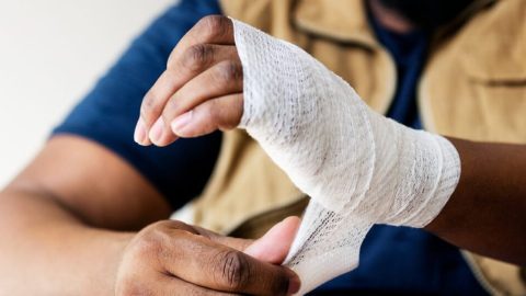 Man wrapping wounded hand