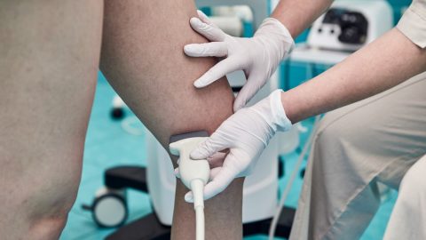 Doctor performing ultrasound on leg