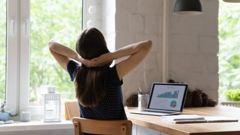 Person sitting at desk with hands on back of neck